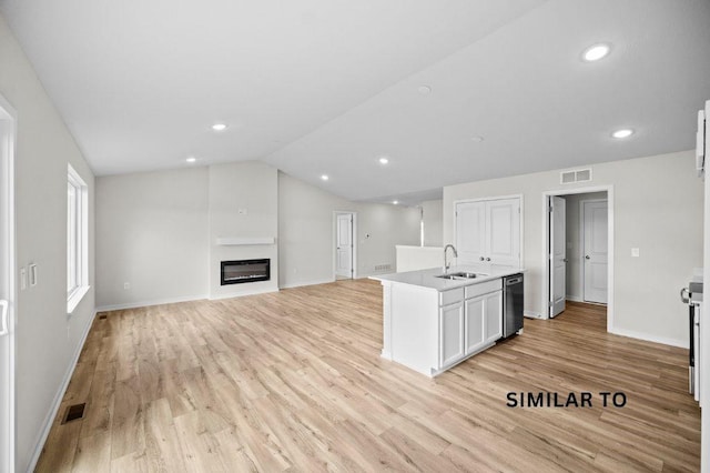 4404 Honey Bee Rdg, Des Moines, IA 50317 - kitchen featuring dishwasher, a sink, light wood-style floors, baseboards, and a center island with sink