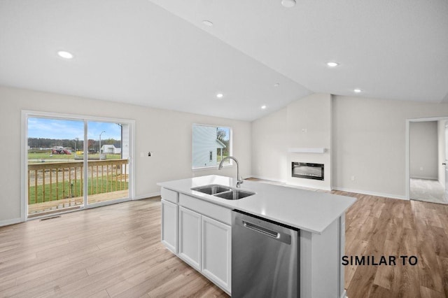 4404 Honey Bee Rdg, Des Moines, IA 50317 - kitchen with a sink, stainless steel dishwasher, light wood-style floors, a glass covered fireplace, and vaulted ceiling