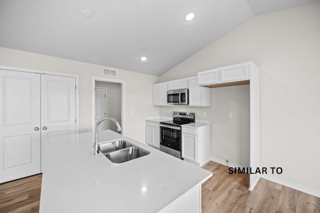 4404 Honey Bee Rdg, Des Moines, IA 50317 - kitchen with appliances with stainless steel finishes, a sink, vaulted ceiling, white cabinetry, and light wood-type flooring