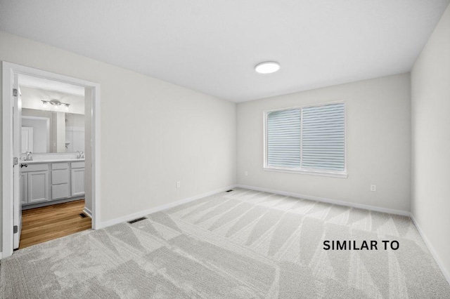 4404 Honey Bee Rdg, Des Moines, IA 50317 - unfurnished bedroom featuring light colored carpet, baseboards, ensuite bathroom, and a sink