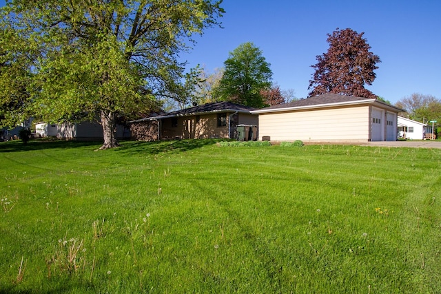 view of grassy yard featuring a garage