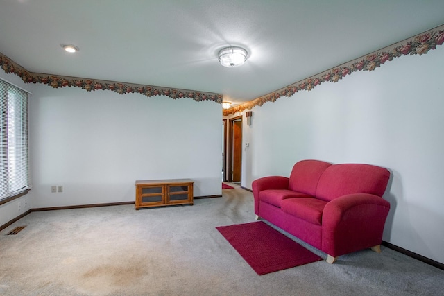 carpeted living area featuring plenty of natural light and baseboards