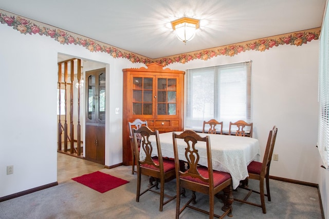 carpeted dining room with baseboards