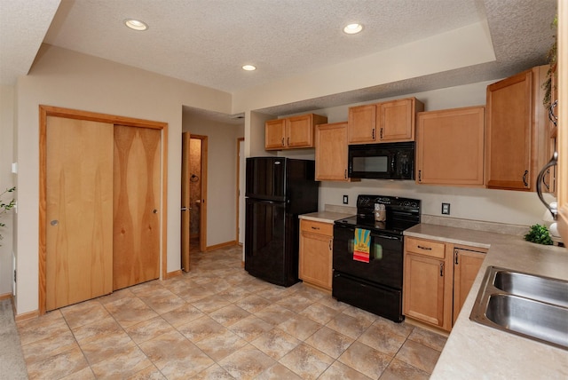kitchen featuring black appliances, light countertops, a sink, a textured ceiling, and recessed lighting