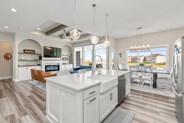 3316 NW 27th St, Ankeny, IA 50023 - kitchen featuring a sink, stainless steel appliances, a glass covered fireplace, recessed lighting, and light wood finished floors