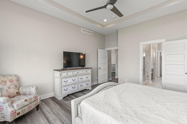3316 NW 27th St, Ankeny, IA 50023 - bedroom with wood finished floors, baseboards, a raised ceiling, a ceiling fan, and ensuite bathroom