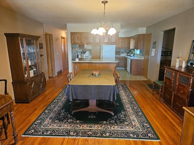 1991 190th Ave, Osceola, IA 50213 - dining space featuring a chandelier, light wood-style flooring, and a textured ceiling