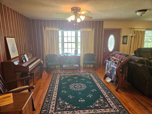 1991 190th Ave, Osceola, IA 50213 - living area with a textured ceiling, ceiling fan, wood finished floors, and wallpapered walls