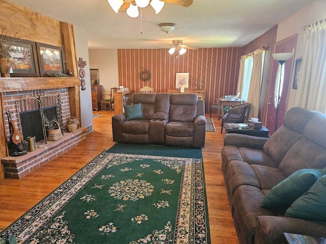 1991 190th Ave, Osceola, IA 50213 - living area featuring ceiling fan, wood finished floors, a textured ceiling, and a brick fireplace