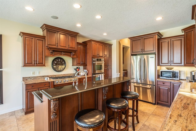 9257 Sugar Creek Dr, West Des Moines, IA 50266 - kitchen featuring stainless steel appliances, a breakfast bar, recessed lighting, a textured ceiling, and an island with sink