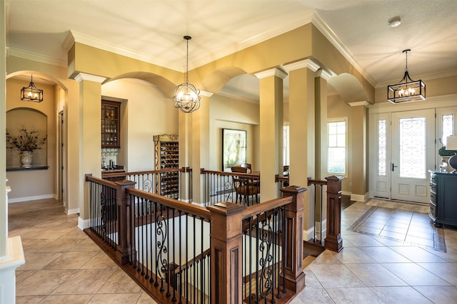 9257 Sugar Creek Dr, West Des Moines, IA 50266 - entrance foyer featuring a chandelier, light tile patterned flooring, crown molding, baseboards, and arched walkways