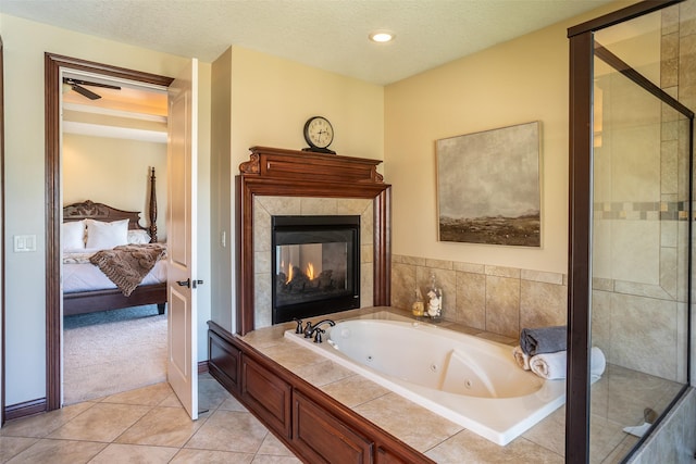 9257 Sugar Creek Dr, West Des Moines, IA 50266 - ensuite bathroom featuring a whirlpool tub, tile patterned floors, a tiled fireplace, a textured ceiling, and a shower stall
