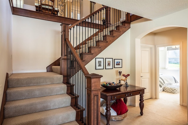 9257 Sugar Creek Dr, West Des Moines, IA 50266 - stairway featuring arched walkways, carpet flooring, and baseboards