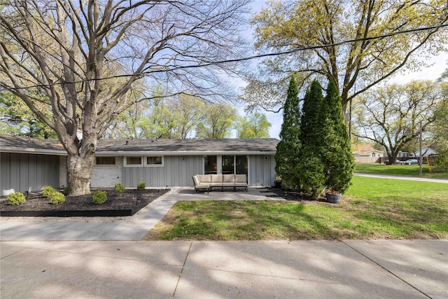 ranch-style home featuring an outdoor hangout area, board and batten siding, a front yard, and a patio area