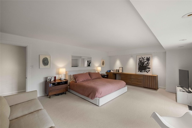 bedroom with light colored carpet and baseboards