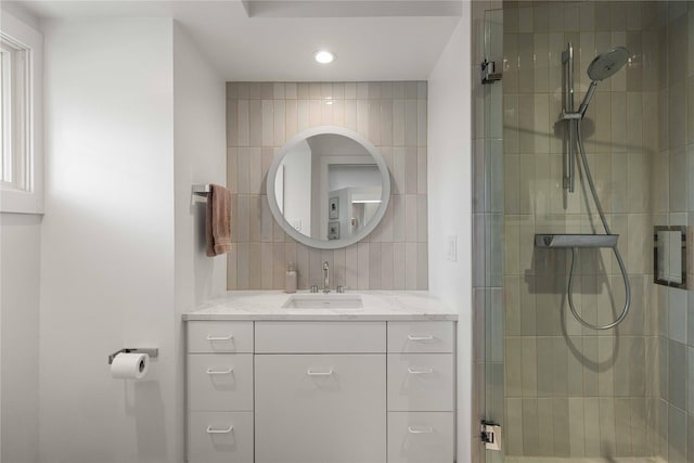 bathroom with tiled shower, recessed lighting, and vanity