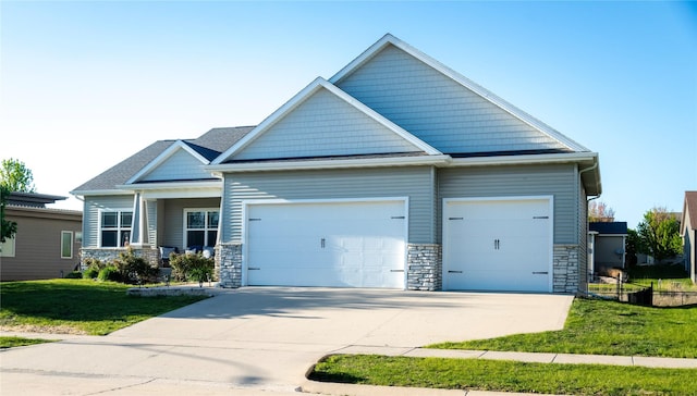 craftsman-style house with an attached garage, stone siding, driveway, and a front lawn