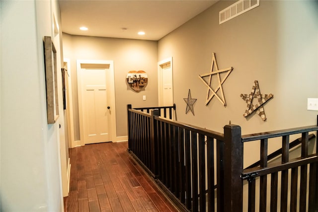 hall featuring an upstairs landing, dark wood-style flooring, recessed lighting, and baseboards