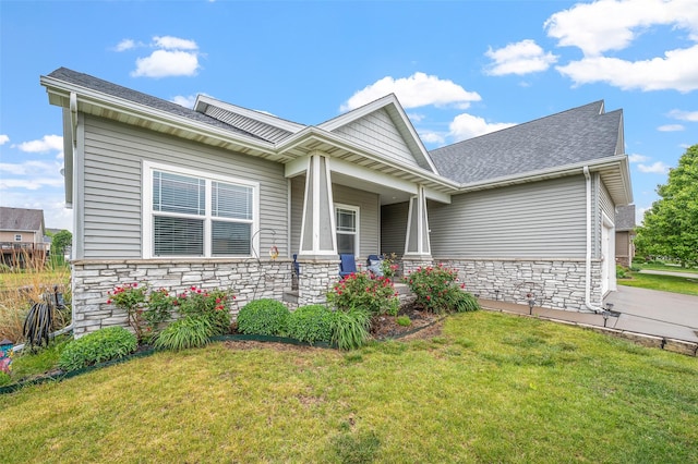 235 Emerson Ln, Waukee, IA 50263 - view of front of house with stone siding, a front yard, a shingled roof, and a porch