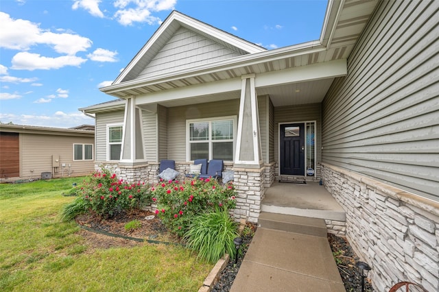 235 Emerson Ln, Waukee, IA 50263 - doorway to property featuring stone siding, a yard, and covered porch