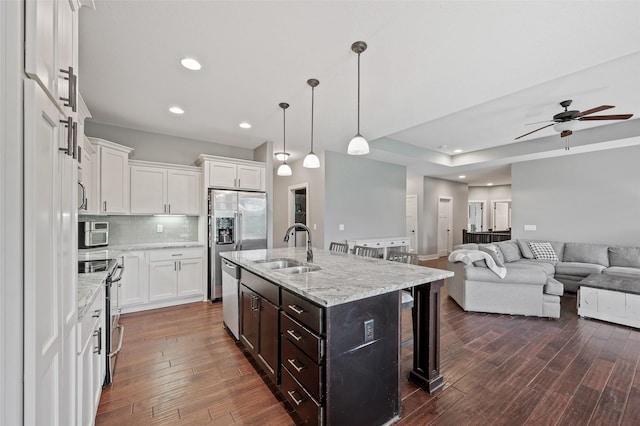 235 Emerson Ln, Waukee, IA 50263 - kitchen featuring a sink, stainless steel appliances, a kitchen bar, white cabinets, and recessed lighting