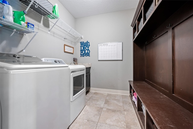235 Emerson Ln, Waukee, IA 50263 - laundry area with washing machine and dryer, cabinet space, baseboards, and light tile patterned floors
