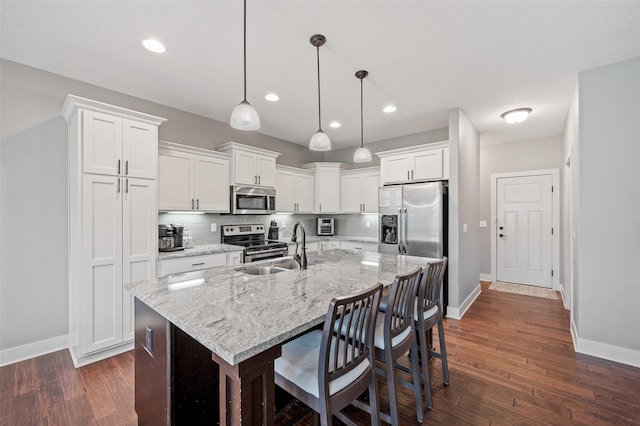 235 Emerson Ln, Waukee, IA 50263 - kitchen featuring stainless steel appliances, a sink, baseboards, dark wood-style floors, and white cabinets