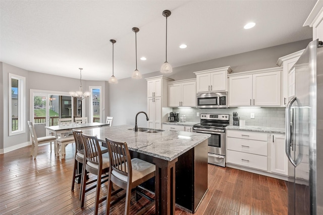 235 Emerson Ln, Waukee, IA 50263 - kitchen featuring stainless steel appliances, a sink, tasteful backsplash, a chandelier, and white cabinetry