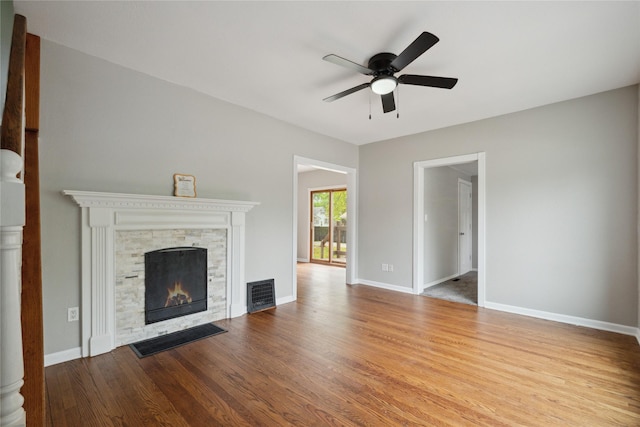 330 E 13th St N, Newton, IA 50208 - unfurnished living room featuring a ceiling fan, wood finished floors, a fireplace, and baseboards