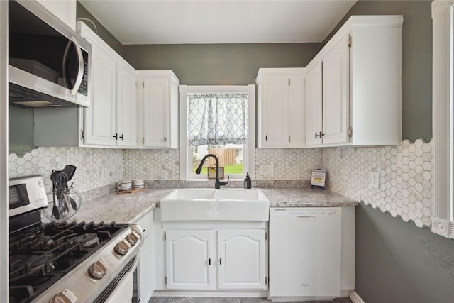 330 E 13th St N, Newton, IA 50208 - kitchen featuring stainless steel appliances, a sink, white cabinets, and backsplash