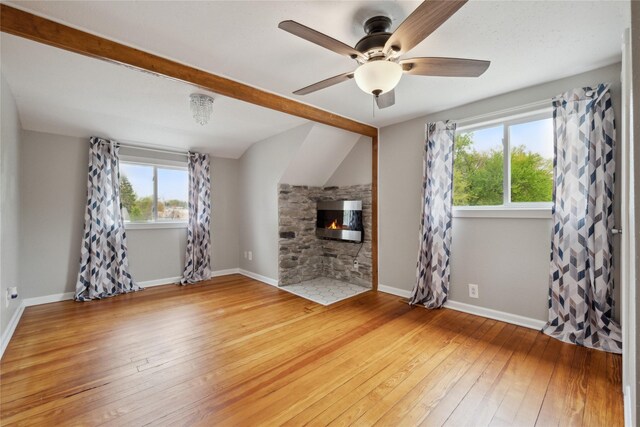 330 E 13th St N, Newton, IA 50208 - unfurnished living room featuring healthy amount of natural light, hardwood / wood-style floors, ceiling fan, and a fireplace