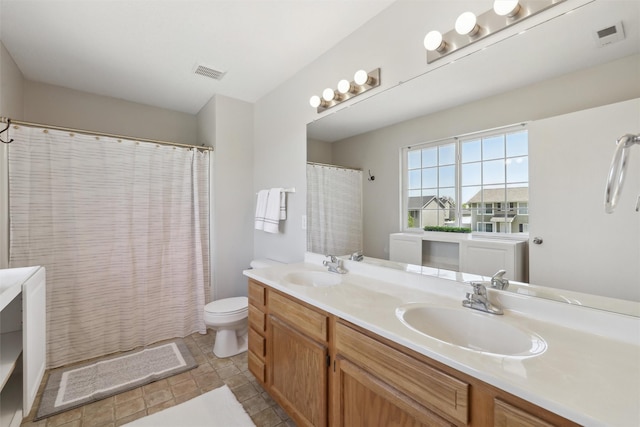 bathroom featuring double vanity and toilet