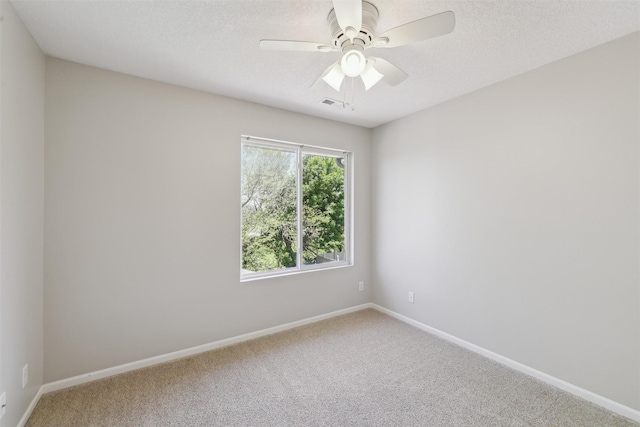 spare room featuring carpet, baseboards, a ceiling fan, and a textured ceiling