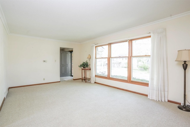 spare room with light colored carpet, baseboards, and ornamental molding