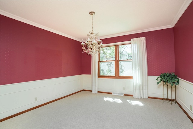 carpeted spare room with a chandelier, a wainscoted wall, and ornamental molding