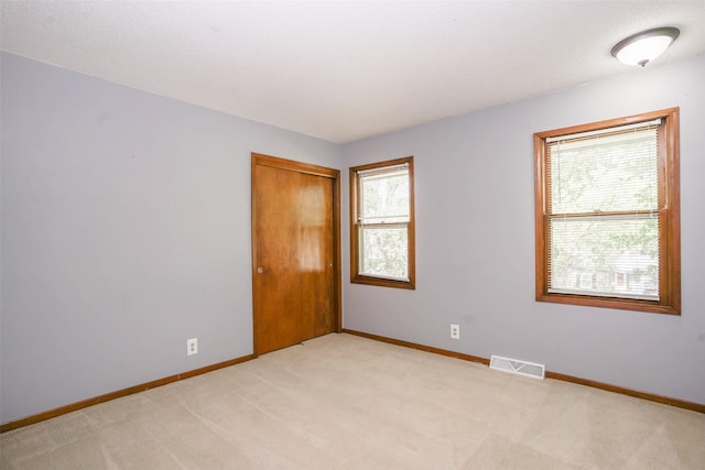 empty room with baseboards and light carpet