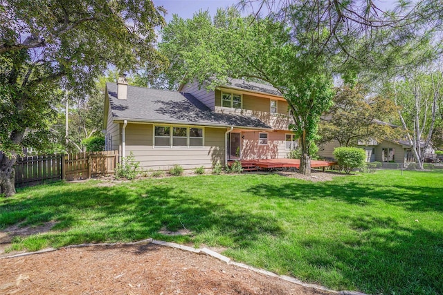 back of property featuring a chimney, a wooden deck, and roof with shingles