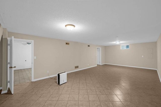 below grade area featuring baseboards and a textured ceiling
