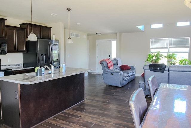 4917 Richmond Ave, Des Moines, IA 50317 - kitchen featuring fridge with ice dispenser, black microwave, open floor plan, and a sink
