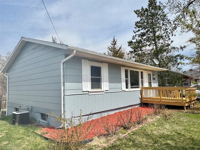 view of side of property with a deck, central AC unit, and a lawn
