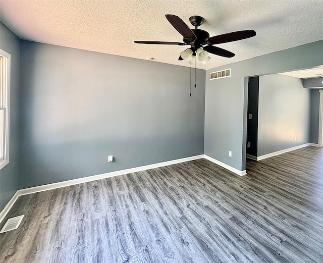 spare room with a ceiling fan, a textured ceiling, wood finished floors, and baseboards