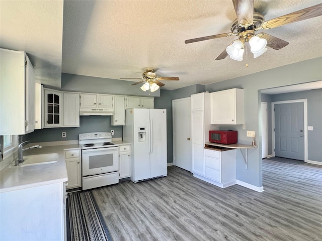 kitchen with white appliances, under cabinet range hood, a sink, ceiling fan, and a textured ceiling