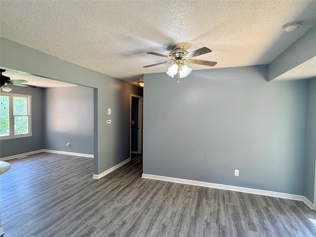 unfurnished room with a ceiling fan, wood finished floors, a textured ceiling, a smoke detector, and baseboards