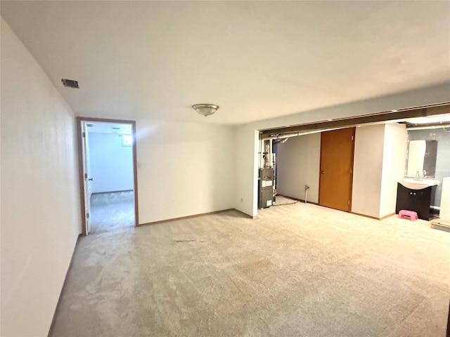 unfurnished living room with light carpet and baseboards