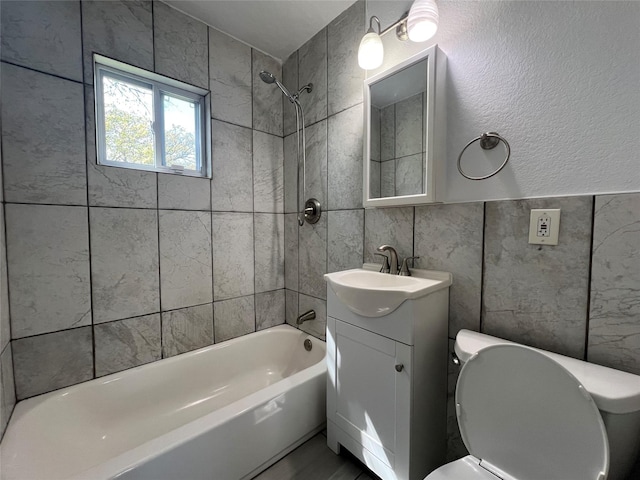 bathroom featuring toilet,  shower combination, vanity, and tile walls