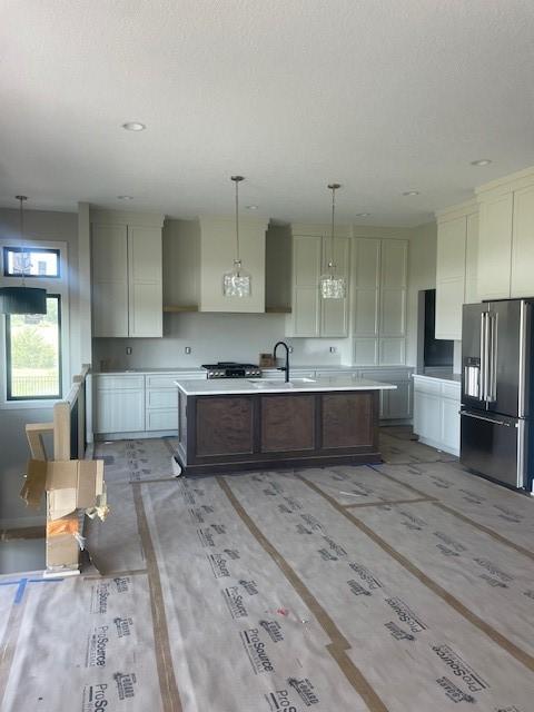 8236 Mahon Ct, Johnston, IA 50131 - kitchen featuring high end fridge, a center island with sink, light countertops, and pendant lighting