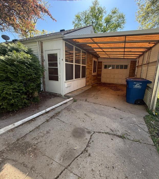 rear view of house featuring asphalt driveway, an attached carport, and a garage