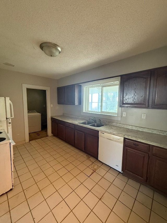 kitchen featuring white appliances, a sink, washer / clothes dryer, a textured ceiling, and light countertops
