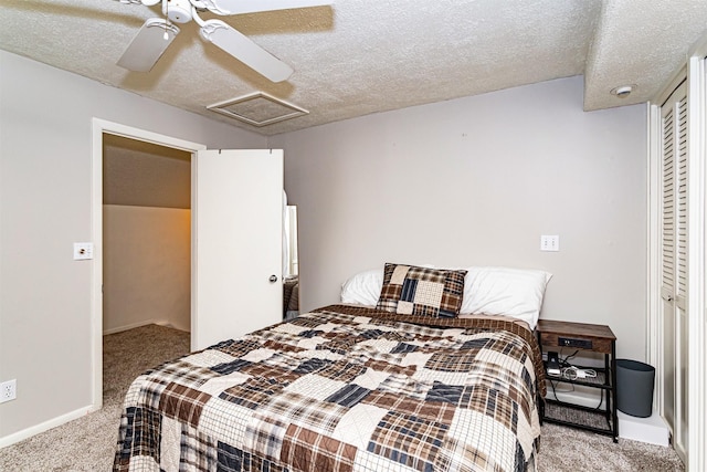 bedroom with carpet, attic access, a textured ceiling, a closet, and baseboards