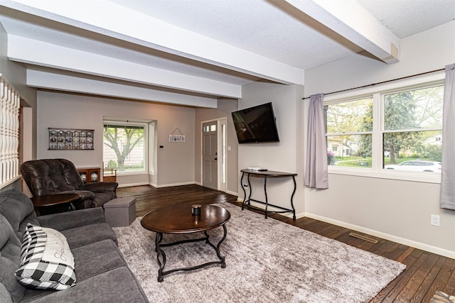 living area featuring beam ceiling, dark wood-type flooring, and baseboards